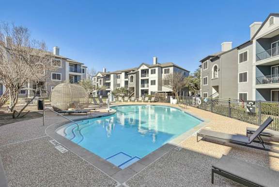 A pool surrounded by apartment buildings and a sun lounger.at Onyx183, Austin Texas