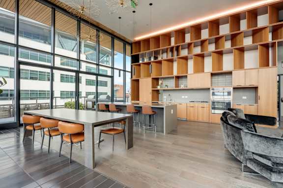 A modern kitchen with a long table and chairs. at Channel House, Oakland, California