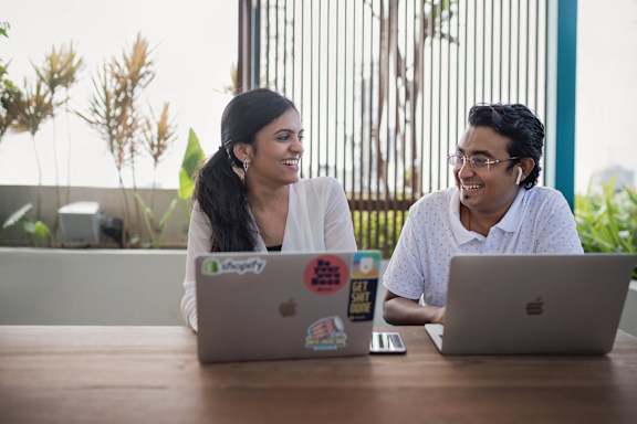 Two people sitting at a table with laptops at Coro Apartments, California 90016