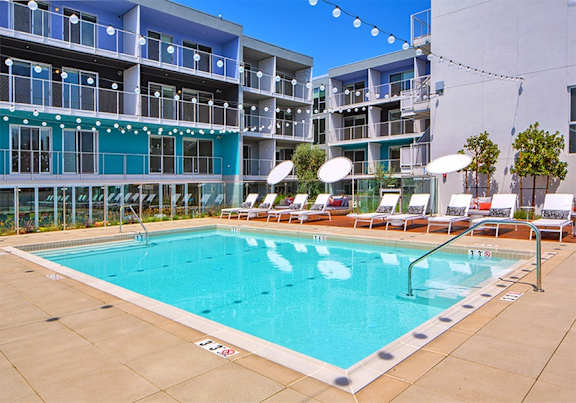 A large swimming pool in front of a multi-story apartment building.at Prizma, Los Angeles, CA
