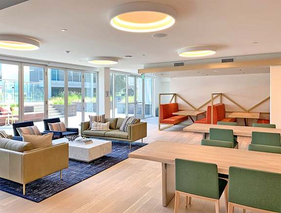 A modern living room with a sofa set, a coffee table, and a dining table.at Prizma, Los Angeles, 90038