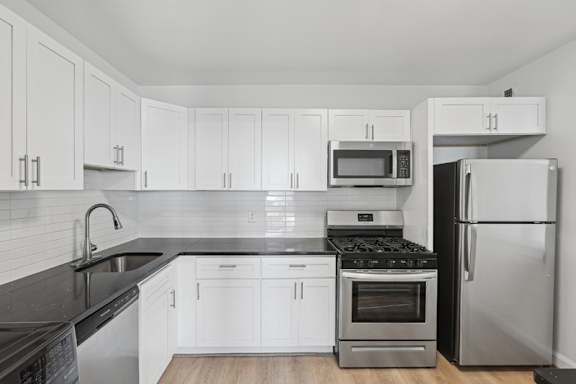 A kitchen with white cabinets and black countertops. at Stratford at Southern Towers, Alexandria, 22311