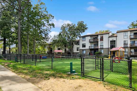A black fence surrounds a playground in a residential area.