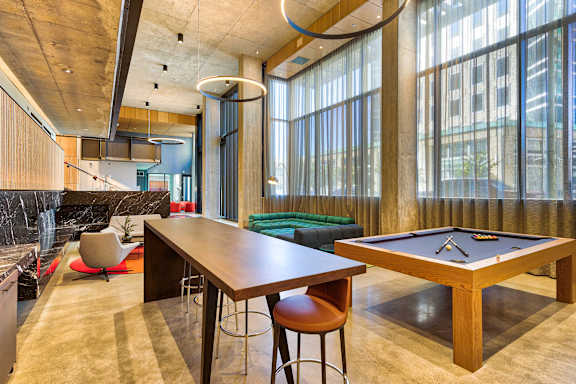 A room with a pool table and a bar area.at Eleven Fifty Clay Street, Oakland, CA 94607