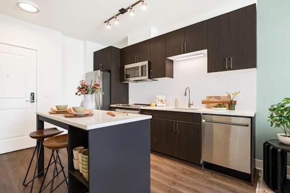 A kitchen with a white counter top and brown cabinets.at The Vale at the Parks, Washington, 20012