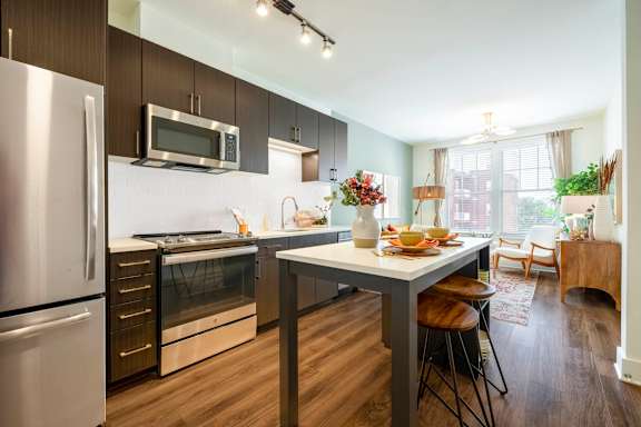 A modern kitchen with a dining table and chairs.at The Vale at the Parks, Washington District of Columbia