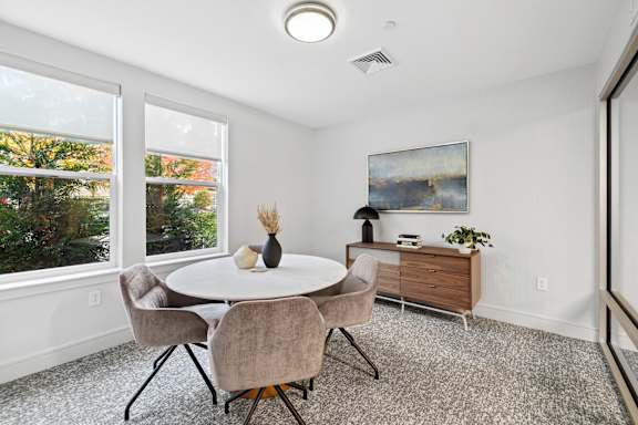 A dining room with a round table and chairs.