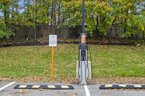A parking sign is next to a parking meter.