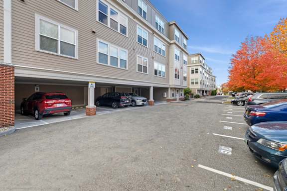 A parking lot with cars parked in front of a building.