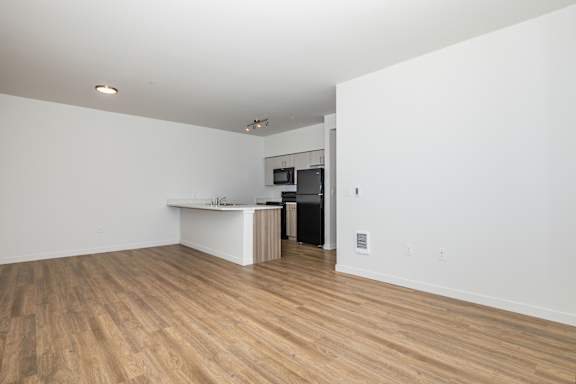 A room with a white counter and a black refrigerator.