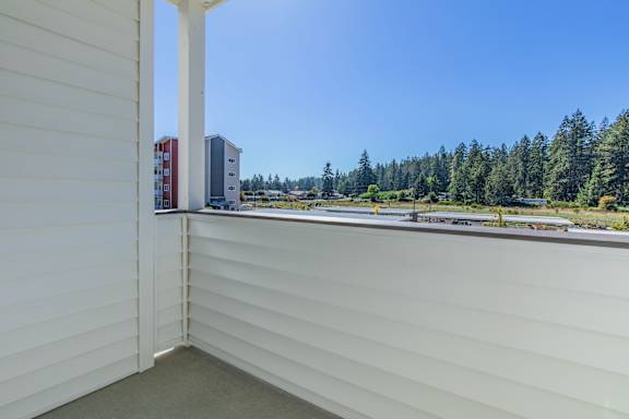 A view from a window of a white building with a red and white building in the distance.