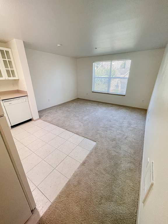 A room with a window and a washing machine.