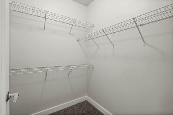 Empty white walk in closet with shelves.