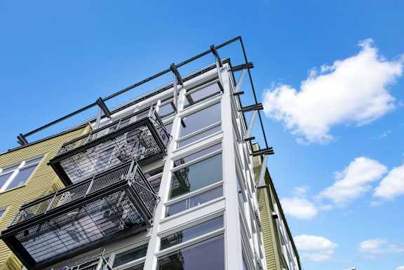 A modern building with a balcony and a glass facade.
