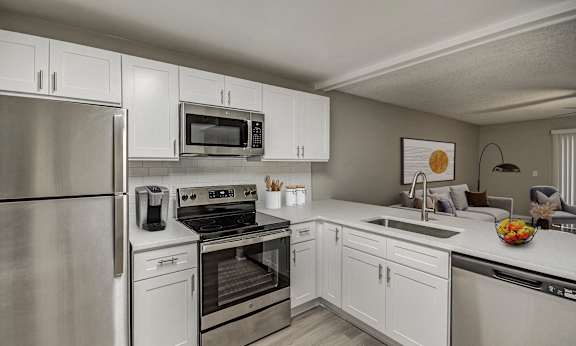 A modern kitchen with stainless steel appliances and white cabinets.