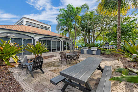 A patio with a table and chairs is surrounded by trees.