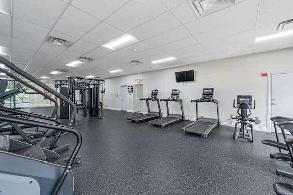 A gym with treadmills, elliptical machines, and other cardio equipment.