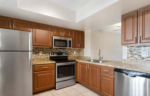 A kitchen with wooden cabinets and stainless steel appliances.