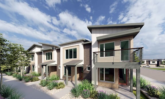 A row of modern houses with a clear blue sky above them.