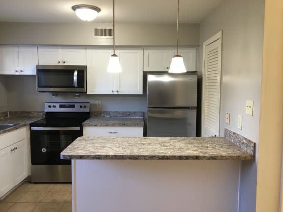 a kitchen with white cabinets and a granite counter top