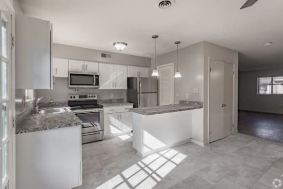 a kitchen with granite counter tops and stainless steel appliances
