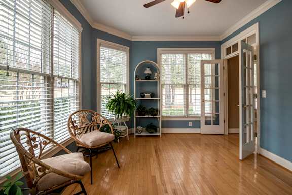 A room with a chair and a fan.