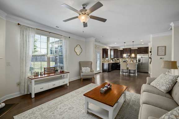 A living room with a white couch and a wooden coffee table.