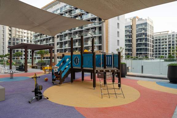 A playground with a slide and a climbing frame.