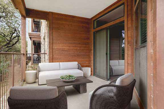 A patio with a couch, chairs, and a coffee table.
