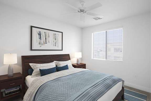 A bedroom with a bed, nightstands, and a ceiling fan.