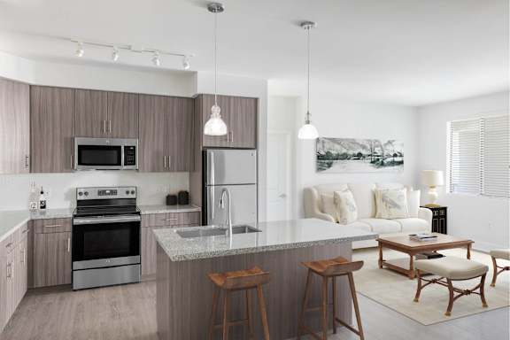 A modern kitchen with a large island and a dining area.