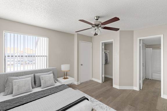 A bedroom with a bed, a ceiling fan, and a window with blinds.