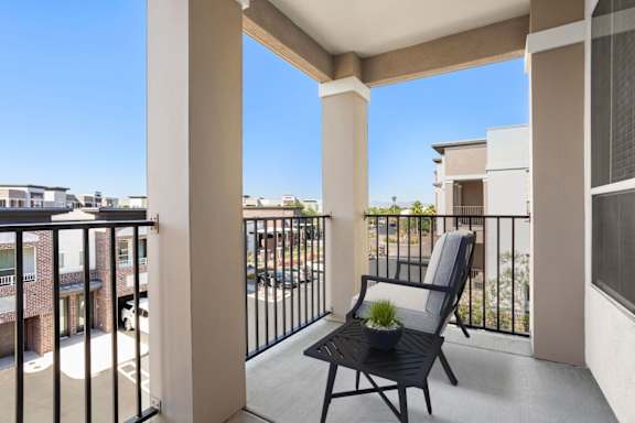 A balcony with a chair and a potted plant.