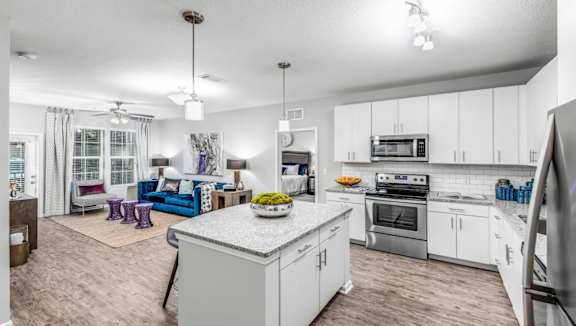 A modern kitchen with a large island and a dining area with a sofa and chairs.