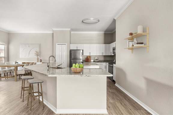 A kitchen with a white island and wooden floors.