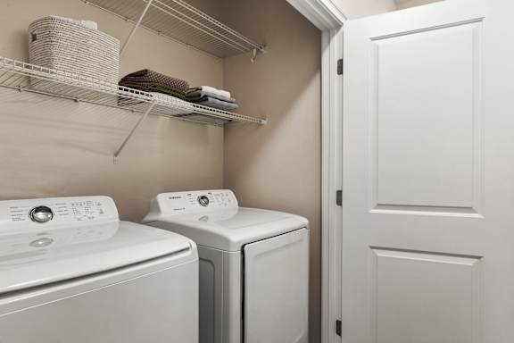 A white washing machine and dryer in a small laundry room.