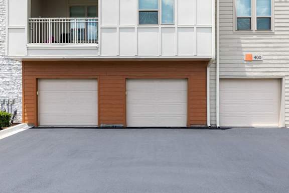 A building with a balcony and a garage door.
