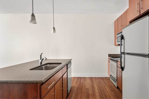 A kitchen with a sink and a refrigerator.