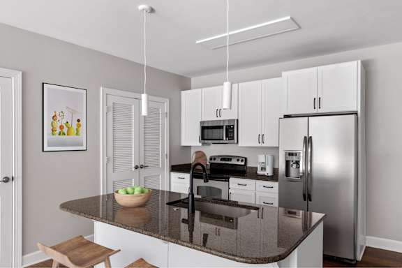 A modern kitchen with a granite countertop and stainless steel appliances.