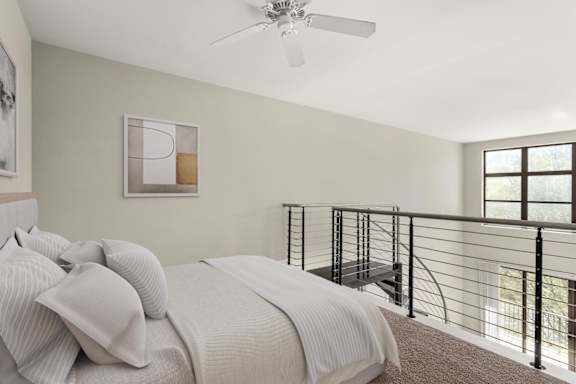 A bedroom with a bed, a ceiling fan, and a balcony.
