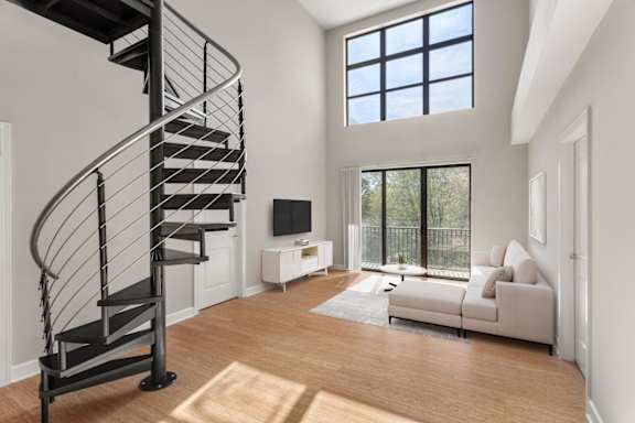 A living room with a spiral staircase and a couch.