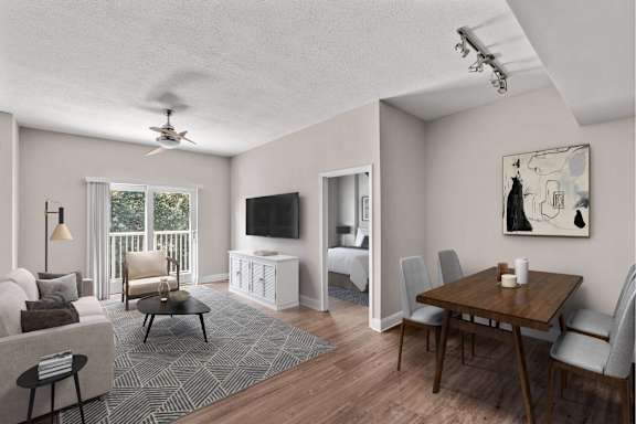 A living room with a television, a couch, a chair, a table, and a painting on the wall.