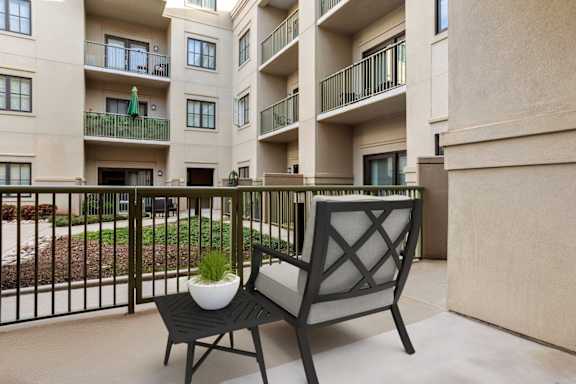 A black chair with a white pot on it is in front of a building.