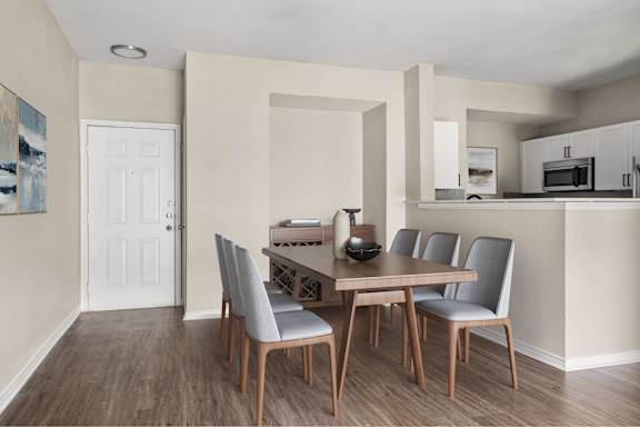 A dining room with a wooden table and grey chairs.