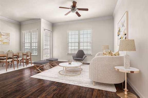 A living room with a white couch, a wooden coffee table, and a ceiling fan.