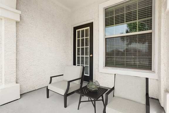 A chair and a table are placed in front of a window.