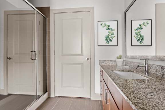 A bathroom with a sink, mirror, and two doors.