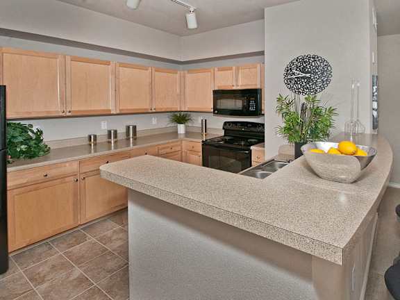 A kitchen with a counter and a bowl of lemons on it.