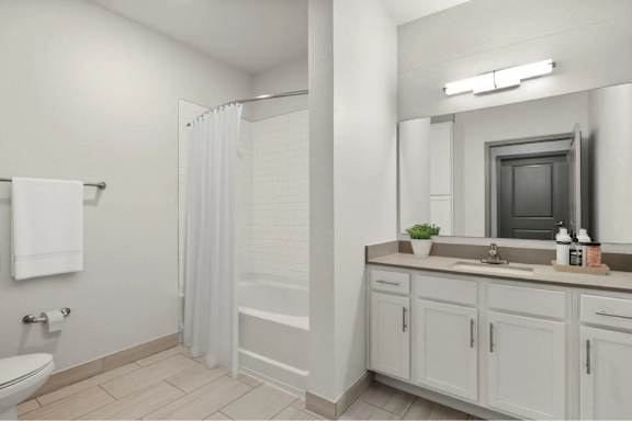 A bathroom with a white toilet, sink, and shower.