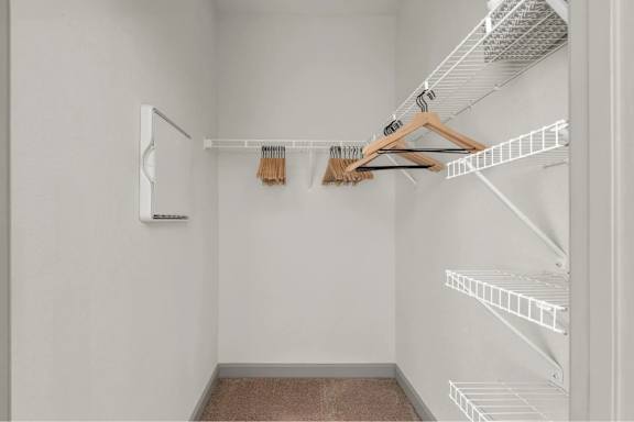 A white closet with a hanger and a shelf.